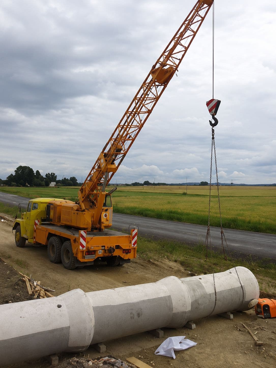Autojeřáb zvedá betonový dílec na stavbě